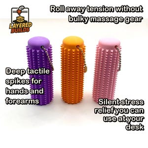 May include: Three cylindrical massage rollers in purple, orange, and light pink, each featuring a textured surface with small spikes and a metal ball chain attached to the top. Text reads: Roll away tension without bulky massage gear, Deep tactile spikes for hands and forearms, Silent stress relief you can use at your desk, and Layered Builds.