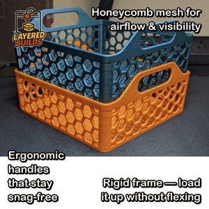 May include: Two stackable storage crates with a honeycomb mesh pattern for airflow and visibility. The top crate is dark blue, and the bottom crate is orange. Both feature ergonomic handles and a rigid frame. Text reads: Honeycomb mesh for airflow & visibility, Ergonomic handles that stay snag-free, Rigid frame—load it up without flexing, and LAYERED BUILDS.