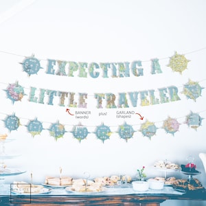 May include: A baby shower banner with a map theme. The banner says "Expecting a Little Traveler". The banner is made of paper and has a blue and white color scheme.