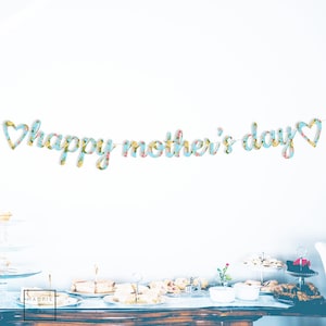 May include: A blue and white floral patterned banner with the text "happy mother's day" in a cursive font. The banner is strung with hearts at each end.