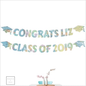 May include: A graduation banner with a map design. The banner says "Congrats Liz Class of 2019".