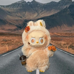 May include: A light peach-coloured bunny doll with a round face and large eyes. The doll is wearing a fuzzy hooded outfit and holding a bouquet of orange roses and a bubble tea. The background features a road and mountains.