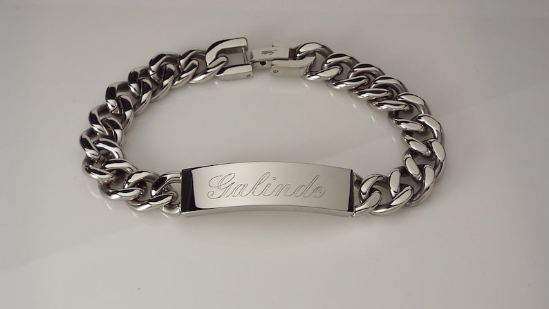 May include: A silver chain bracelet with a rectangular tag engraved with the name "Galindo".
