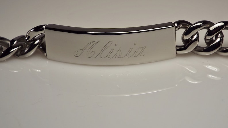 May include: A silver chain bracelet with a rectangular tag engraved with the name "Alissia".