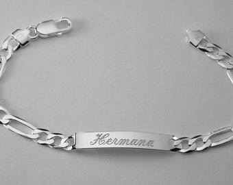 May include: A silver chain bracelet with a rectangular tag engraved with the name "Hermana".