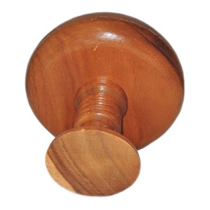 May include: A wooden pedestal with a round top and a round base. The pedestal is made of light brown wood and has a smooth finish.