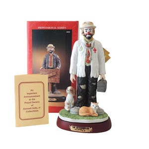 May include: A ceramic figurine of a clown dressed as a veterinarian, holding a medical bag, with a dog and cat at his feet. The figurine is part of the "Professional Series" and includes a box and announcement card.
