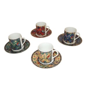 May include: Four porcelain espresso cups and saucers. Each cup and saucer features a different colorful floral and bird design. The cups have white interiors and curved handles. The saucers are round with a scalloped edge.