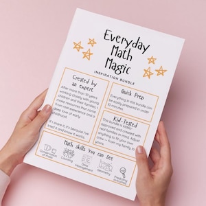 May include: A white paper titled "Everyday Math Magic Inspiration Bundle" is held by a person. The paper features text and illustrations, including stars and sections labeled "Created by an expert," "Quick Prep," and "Kid-Tested." The paper is held against a pink background.