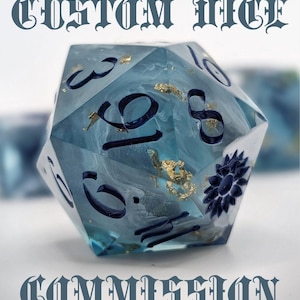 May include: A bespoke, twelve-sided die with a translucent blue resin body. The die features dark blue numerals and a decorative floral design. Gold flakes are embedded within the resin. The text "CUSTOM DICE COMMISSION" is displayed above and below the die.