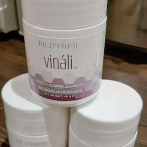 May include: Three white cylindrical containers of Nutrifii Vináli food supplement. Each container has a white lid and a label with the brand name, product name, and supplement information. The net weight is 40 g.