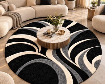 Peut inclure: Un grand tapis rond présentant un motif contrasté de bandes courbes et balayantes en noir, crème et gris anthracite. Le tapis possède une surface en velours texturé avec un design abstrait répétitif qui rayonne vers l'extérieur en mouvement circulaire.