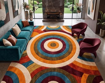 Peut inclure: Un grand tapis rectangulaire présentant un motif géométrique audacieux composé de cercles concentriques et d'arcs dans des tons vifs d'orange, de bleu sarcelle, de bordeaux et de crème, disposé dans un salon avec un canapé bleu sarcelle.