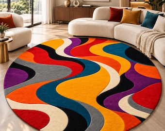 Peut inclure: Un grand tapis circulaire présentant un motif multicolore vibrant composé de bandes ondulées fluides dans des tons orange, jaune, rouge, bleu sarcelle, violet, noir, gris et crème, créant un effet visuel dynamique et superposé.