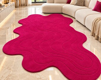 May include: A large, vibrant magenta area rug with an irregular, organic, wavy shape. The rug features a textured surface with carved, flowing lines that follow the contours of its unique, non-rectangular, blob-like silhouette.