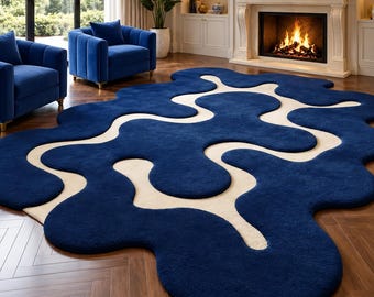 May include: A large area rug featuring an irregular, organic shape with a deep navy blue pile and contrasting cream-colored flowing lines that create a fluid, interconnected pattern across the surface of the floor covering.