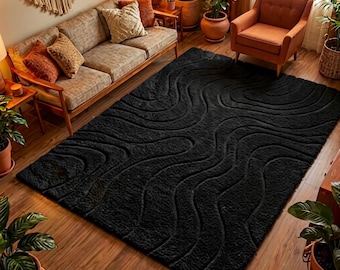 May include: A rectangular area rug in a solid black color featuring a raised, textured pattern of flowing, wavy lines that create a topographical effect across the entire surface of the floor covering, providing a deep pile and tactile finish.
