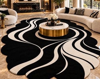 May include: A large, oval-shaped area rug featuring a bold, high-contrast pattern of flowing, organic black and white lines. The rug has a scalloped, cloud-like edge and is positioned on a polished, light-colored marble floor.