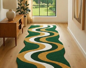 May include: A green, gold, and white wavy runner rug. The rug has a dark green background with a wavy pattern in gold and white. The rug is placed on a wooden floor in a hallway.