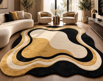 May include: An area rug featuring an irregular, organic shape with layered, wavy bands of color. The design consists of alternating sections of deep black, warm mustard yellow, and soft cream, creating a fluid, abstract pattern.