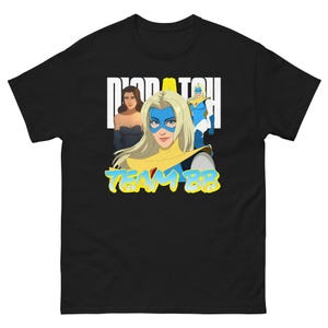Może przedstawiać: Czarny t-shirt z krótkim rękawem z grafiką przedstawiającą trzy kobiety z kreskówek. Tekst "DISPATCH" znajduje się nad kobietami, a "TEAM BB" pod spodem. Kobiety mają na sobie niebieskie, żółte i białe kostiumy superbohaterów.