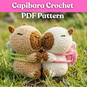 Könnte beinhalten: Zwei gehäkelte Capybara-Plüschtiere, eines in Beige und eines in Weiß, mit braunen Akzenten und geschlossenen Augen, sind in einer grasbewachsenen Umgebung zu sehen. Die Plüschtiere haben kleine Rucksäcke und sind Teil eines PDF-Musters, wie durch den Text oben angegeben.