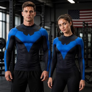 May include: Two long-sleeve compression shirts featuring a black and blue color scheme with a stylized bird emblem on the chest. The shirts have a high neckline and form-fitting design, with black panels on the sides and blue sleeves and chest.