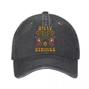 May include: A dark gray baseball cap with a curved brim. The front features a colorful graphic with the text "BILLY STRINGS". The graphic includes sunflowers, frogs, and a flame design. The cap is made of a durable fabric.