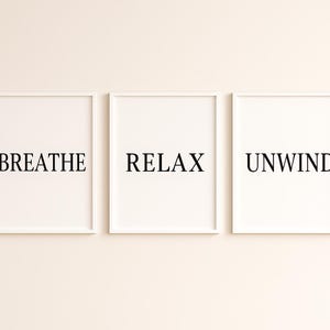 Puede incluir: Tres impresiones art&iacute;sticas enmarcadas con las palabras "Breathe", "Relax" y "Unwind" en negro, fuente sans-serif. Las impresiones tienen fondos blancos y marcos blancos, creando una est&eacute;tica minimalista. La obra de arte se exhibe contra una pared de color neutro.