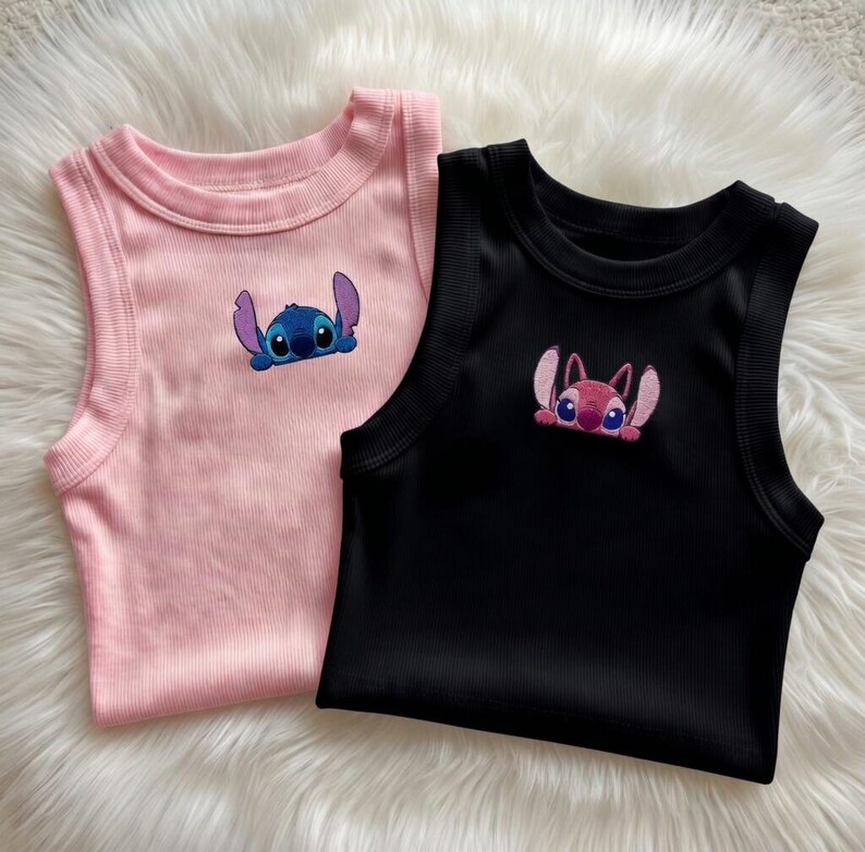 Peut inclure: Deux d&eacute;bardeurs c&ocirc;tel&eacute;s, un rose et un noir, chacun avec un personnage de dessin anim&eacute; brod&eacute;. Le d&eacute;bardeur rose a un personnage bleu, tandis que le noir a un personnage rose. Les deux hauts ont un col rond et sont sans manches.