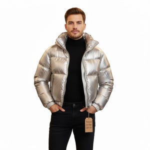 May include: A shiny silver puffer jacket with a high collar and a zipper closure. The jacket has a ribbed hem and cuffs. A tag that says "Handmade Silver Puffer Gift for Her" is attached to the jacket.