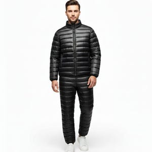 May include: A black, quilted winter suit, including a jacket with a stand-up collar and a full-length zipper, and matching pants. The suit is worn with white sneakers. The outfit is designed for cold weather and outdoor activities.