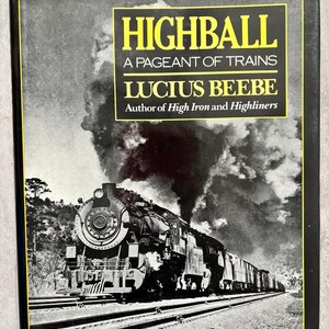 Puede incluir: Portada de libro con una imagen en blanco y negro de un tren de vapor. El título "HIGHBALL A PAGEANT OF TRAINS" está en texto amarillo. El nombre del autor, Lucius Beebe, también se muestra.