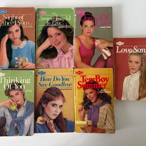 Könnte beinhalten: Eine Sammlung von sieben alten Taschenbüchern für junge Erwachsene mit Titelbildern von jungen Menschen. Die Titel umfassen Night of the Prom, The Summer Jenny Fell In Love, Dance Of Love, Love Song, Thinking Of You, How Do You Say Goodbye und Ten-Boy Summer.