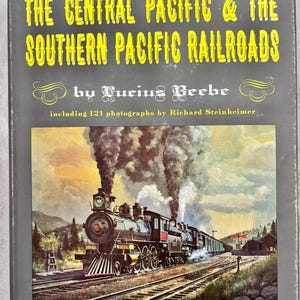 Puede incluir: Portada de libro con el título "THE CENTRAL PACIFIC & THE SOUTHERN PACIFIC RAILROADS" y una ilustración de un tren de vapor. El autor es Lucius Beebe, con 121 fotografías de Richard Steinheimer. Es una edición del centenario.