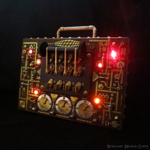 May include: A steampunk-style box with a brown metal exterior and gold accents. The box has a handle on top and features various gears, dials, and switches. There are red lights illuminating the box.
