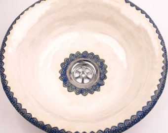 UM1 Rundes Waschbecken aus Keramik. Eine Keramikschale in volkstümlicher Atmosphäre, verziert mit zwei zarten marineblauen Spitzen