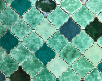 May include: A wall covered in green and blue Moroccan-style tiles. The tiles are arranged in a repeating pattern of quatrefoils.