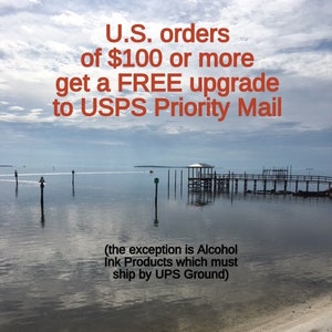 May include: A scenic image of a wooden pier extending into a calm body of water. The sky is a light blue with white clouds. The text "U.S. orders of $100 or more get a FREE upgrade to USPS Priority Mail (the exception is Alcohol Ink Products which must ship by UPS Ground)" is displayed in red text.