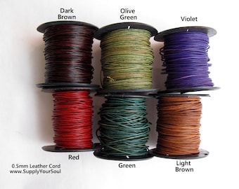 May include: Six spools of 0.5mm leather cord in various colors, including dark brown, olive green, violet, red, green, and light brown. The spools are labeled with the color names. The text "0.5mm Leather Cord" and "www.SupplyYourSoul" is printed below the spools.