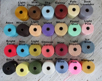May include: A collection of 36 spools of embroidery floss in various colors, including light gold, milk chocolate, sky blue, sienna, pale yellow, dark lavender, aqua, winette, light peach, violet, wheat, pastel mint, light pink, bright coral, nile blue, light maize, chinese coral, wine, light copper, ice blue, black, sunlight, olivine, cream, montana blue, neon pink, and marigold.