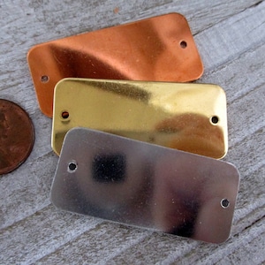 May include: Three rectangular metal tags in different finishes: copper, brass, and silver. Each tag has two holes for attaching.