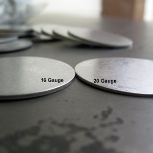 May include: Two silver metal discs, one labelled "16 Gauge" and the other labelled "20 Gauge".
