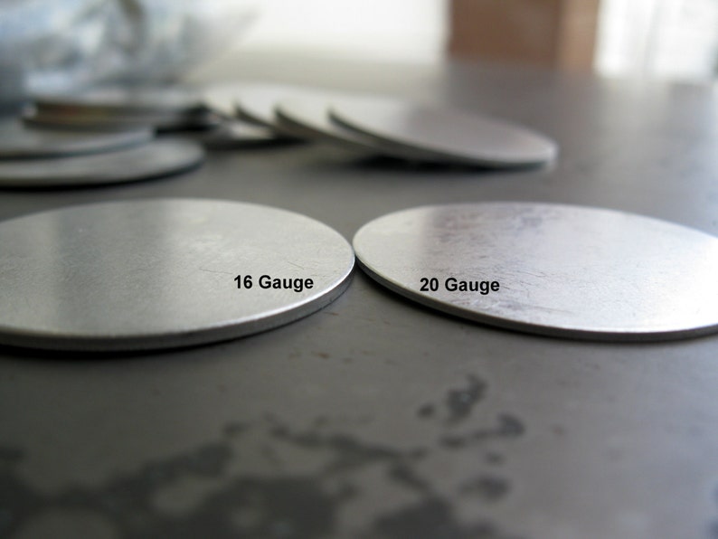 May include: Two silver metal discs, one labelled "16 Gauge" and the other labelled "20 Gauge".