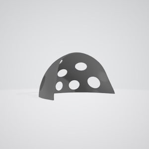 Op de afbeelding: Een donkergrijs, halfrond object met verschillende grote, gelijkmatig verdeelde, ovaalvormige gaten. Het object lijkt gemaakt te zijn van een stevig materiaal en staat tegen een effen, lichtgrijze achtergrond. De vorm lijkt op een gestileerde paddenstoelkap.