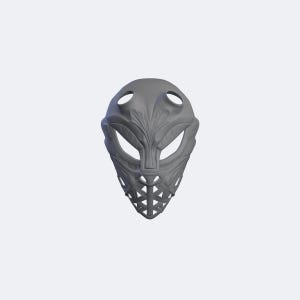 May include: A matte gray, full-face mask featuring an intricate, symmetrical relief pattern across the forehead and cheeks. The design includes two large, almond-shaped eye openings, a central nose bridge, and a lattice-style grid over the mouth area.