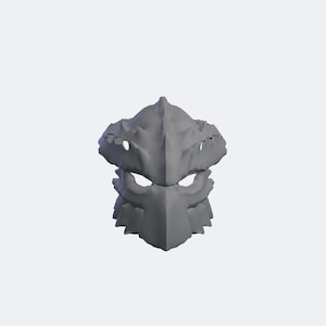 May include: A matte grey, sculpted mask featuring a sharp, angular design with a pointed forehead ridge, prominent brow protrusions, and deep-set eye openings. The surface displays a textured, layered appearance with jagged edges and a central vertical spine.