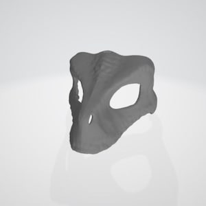 Könnte beinhalten: Eine graue Dinosaurierschädelmaske mit Augenöffnungen. Die Maske hat eine strukturierte Oberfläche und ist zum Tragen bestimmt. Die Maske ist ein Kostümzubehör.