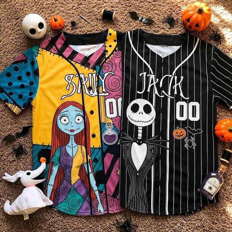 Op de afbeelding: Twee honkbalshirts met Halloween-thema's. E&eacute;n is geel met een Sally-afbeelding, de andere is zwart-wit gestreept met een Jack Skellington-afbeelding. Beide shirts hebben de naam van het personage en een nummer op de voorkant.