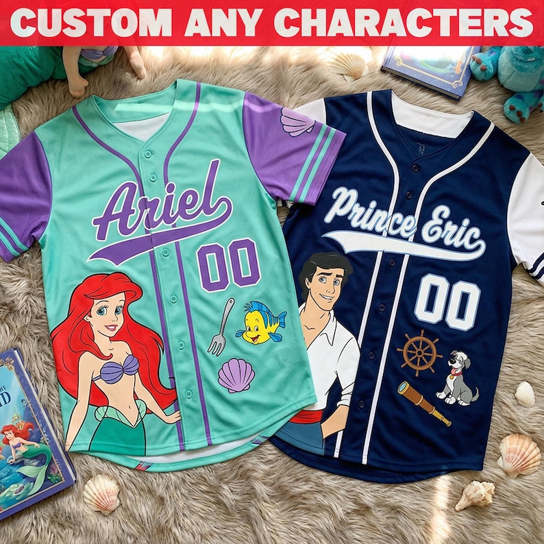 Puede incluir: Dos camisetas de b&eacute;isbol, una turquesa y morada, la otra azul marino y blanca. La camiseta turquesa presenta el nombre "Ariel" y un gr&aacute;fico de sirena. La camiseta azul marino dice "Prince Eric" con un gr&aacute;fico de personaje. Ambas tienen el n&uacute;mero "00". El texto en la parte superior dice "CUSTOM ANY CHARACTERS".